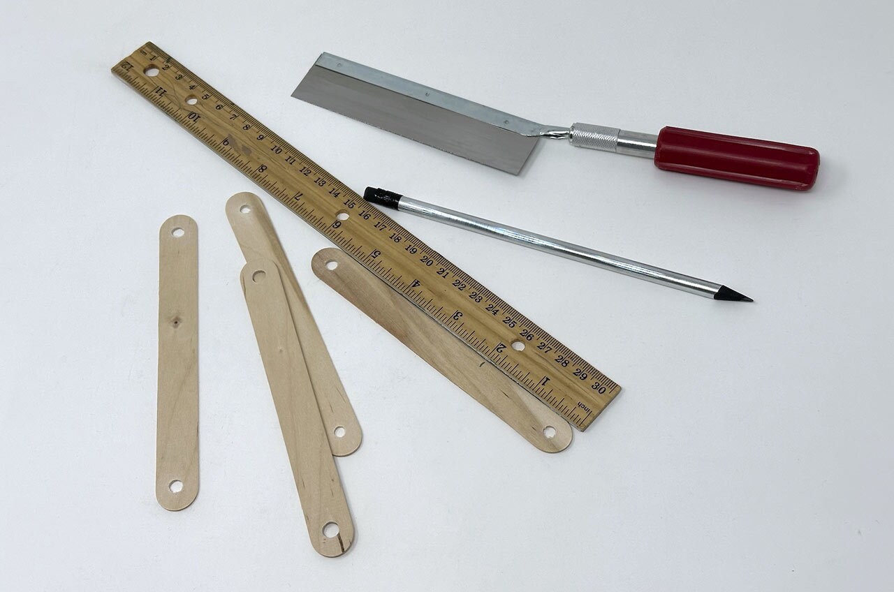 Step 2: Measure and mark two inches from the ends of the craft sticks, then cut for 8 2” leg pieces in total.