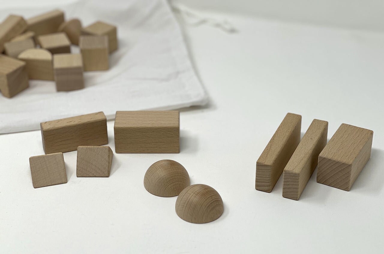Step 4: Cut wood pieces or arrange more toy blocks to make a 1.75” tall x 2” wide body with an angled front. (For example, one thin rectangle block, one wide rectangle block, and two triangle blocks.)