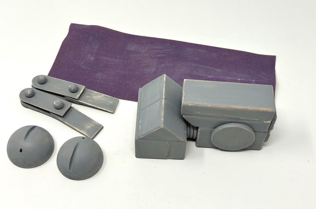 Step 21: Add age and weathering to the painted pieces with sandpaper.