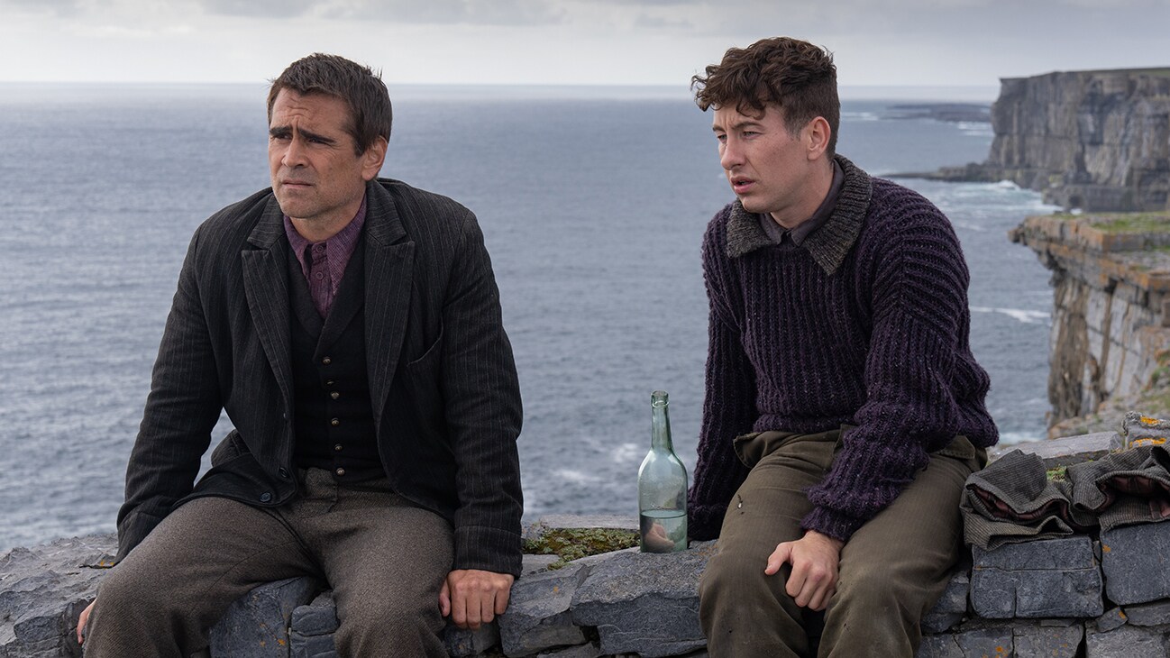 Colin Farrell and Barry Keoghan's characters sit on the edge of a stone wall, overlooking rough Irish sheer cliff faces, a bottle of water between them.