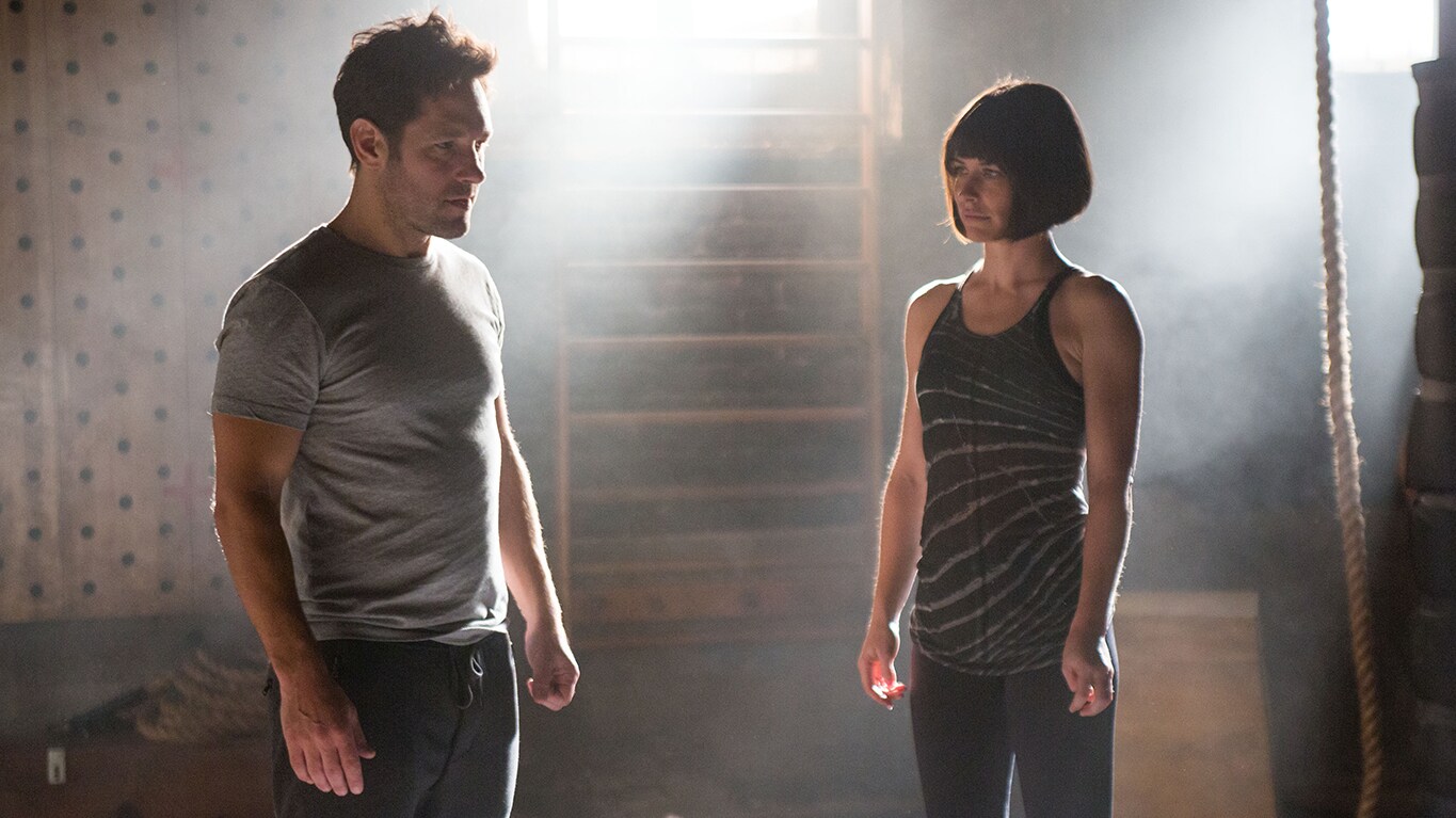 Scott Lang and Hope van Dyne stand across from each other in a dusty training room.