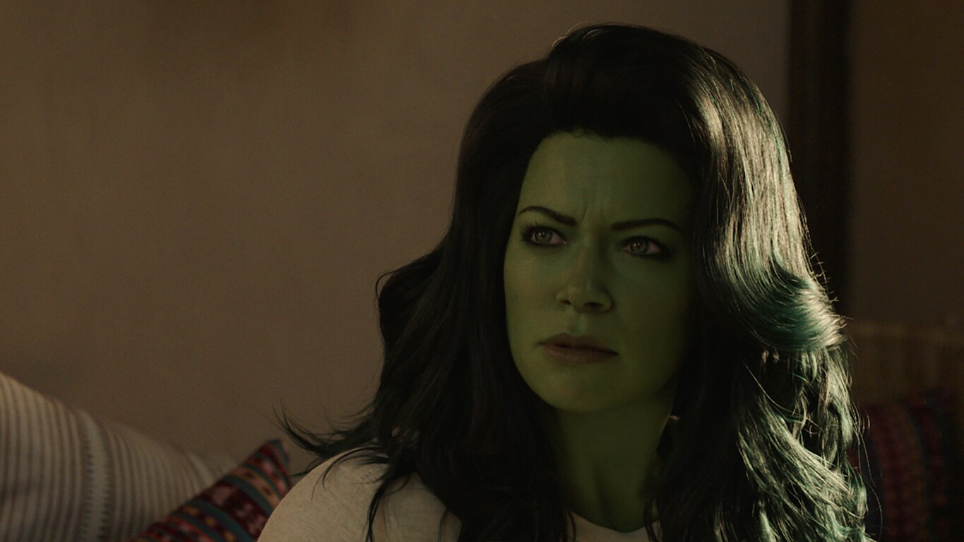 She-Hulk looks to the side, looking confused and slightly angry, with her green skin and green-tinged hair.