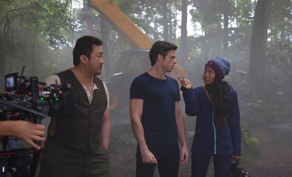 Actors Don Lee and Richard Madden with director Chloé Zhao on the set of Marvel Studios' Eternals streaming on Disney Plus