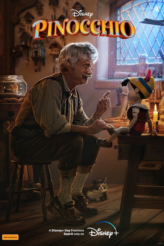 An image of Tom Hanks as Giuseppe, speaking with Pinocchio while sitting on a seat in his workshop.