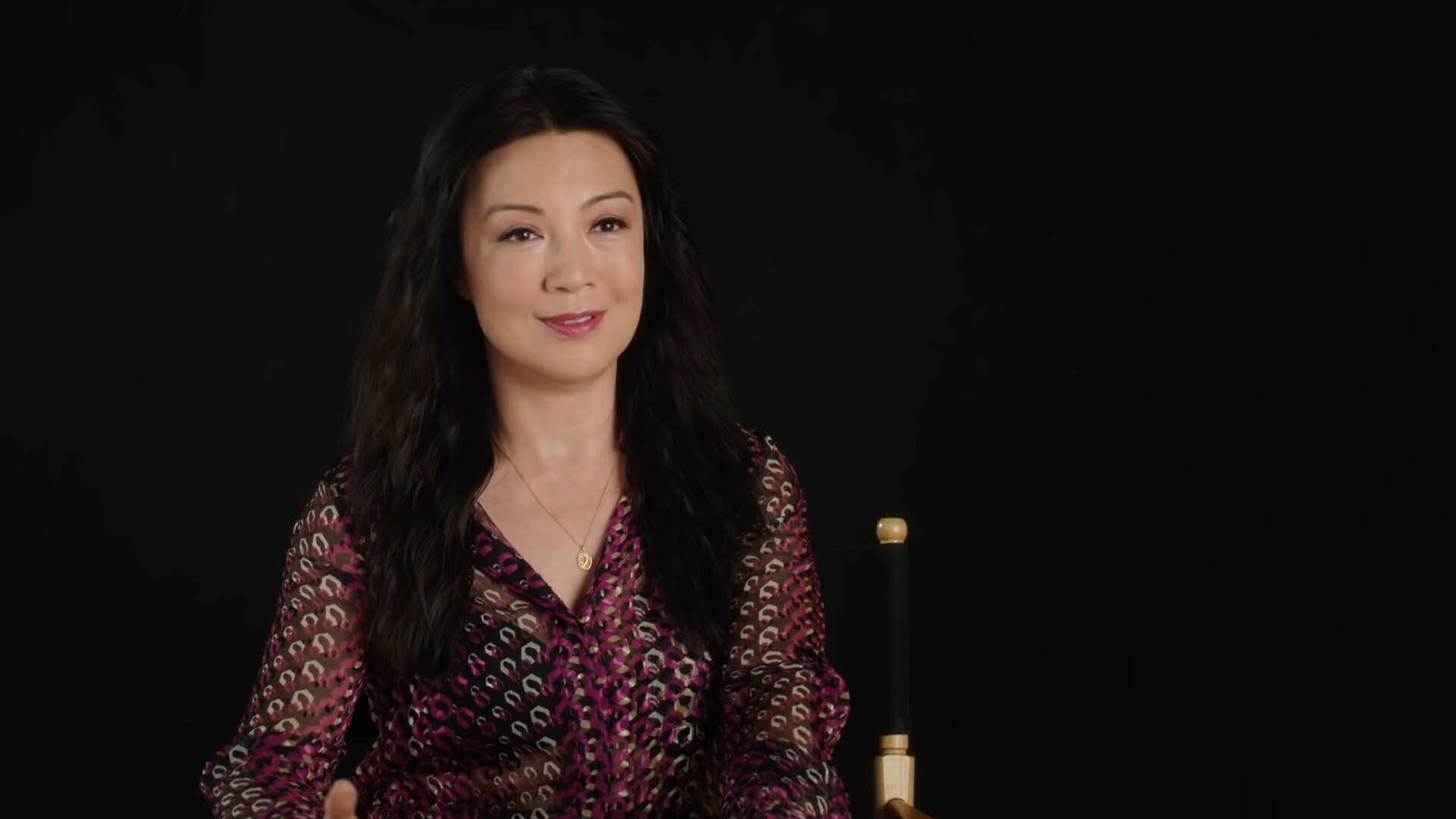Ming-Na Wen sits against a black background and is interviewed about her role in The Book of Boba Fett