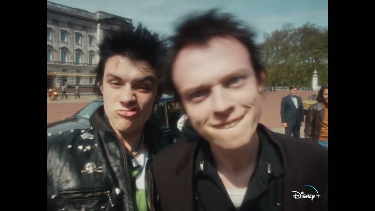Two actors playing members of the punk band the Sex Pistols make funny faces at the camera.