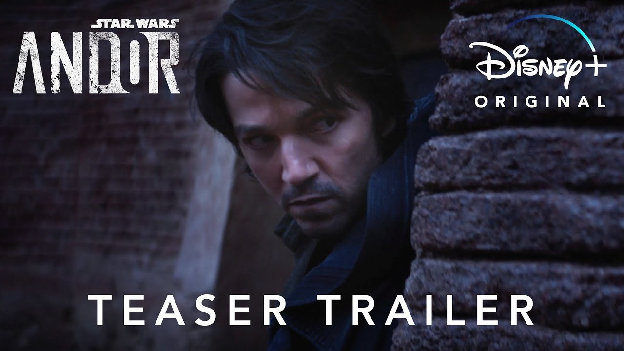 Diego Luna as a character in Star Wars Andor, looks around a corner in a dark and gritty setting.