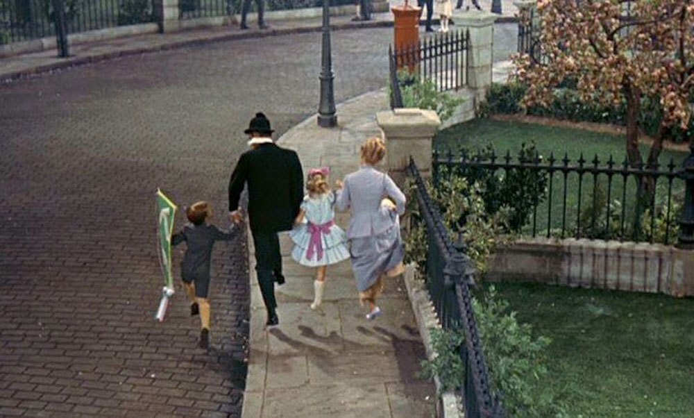 The Banks family skipping along the sidewalk.