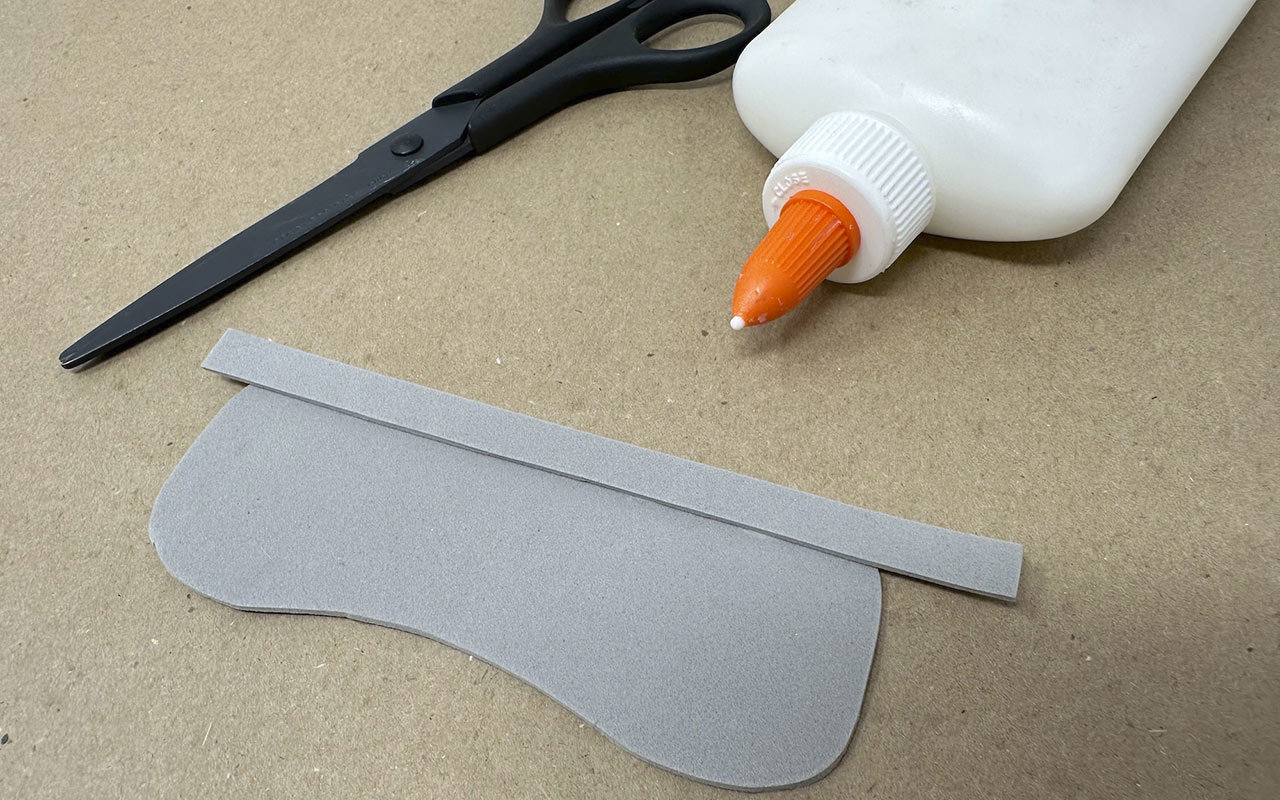 Use the pencil to trace the visor template on the gray craft foam. Cut it out with scissors.