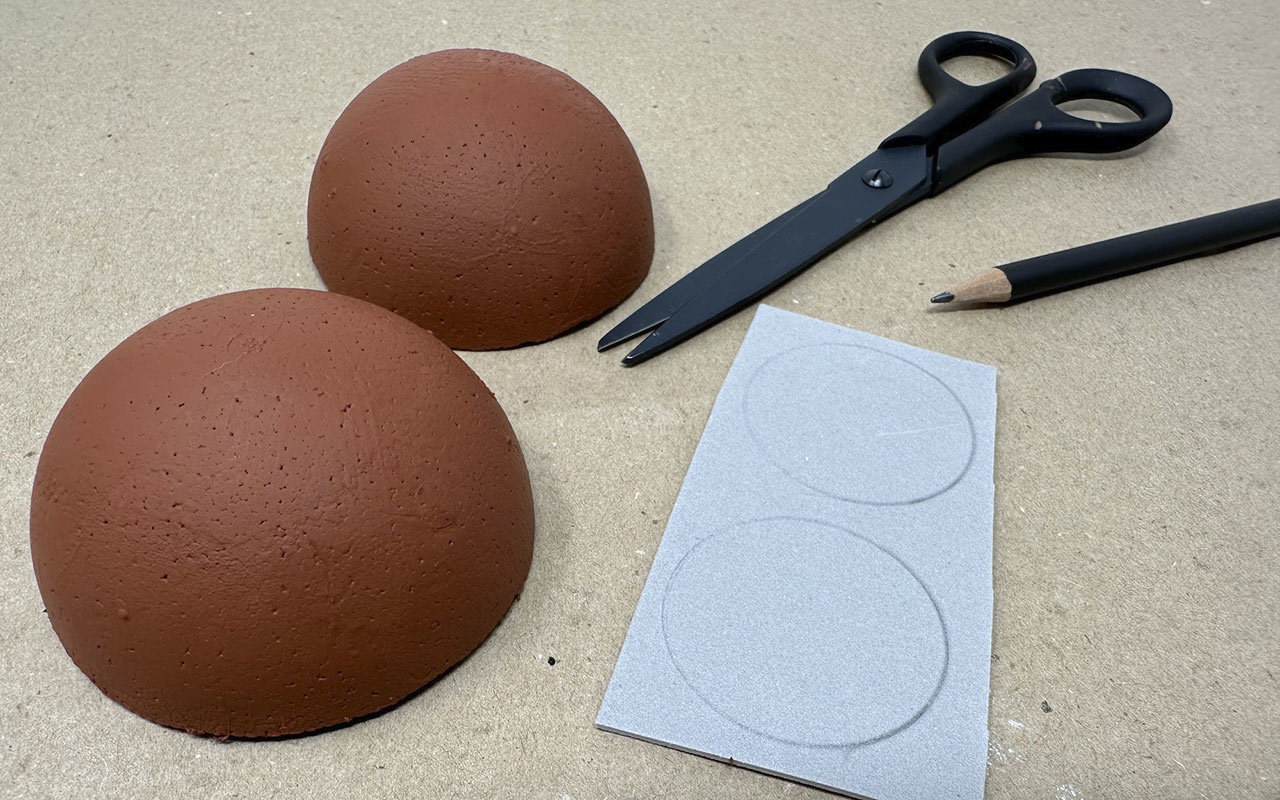 Once the clay pot is dry, paint the bottom half of the oval with the white acrylic paint. Paint the top half with the dark brown acrylic paint. Let dry.