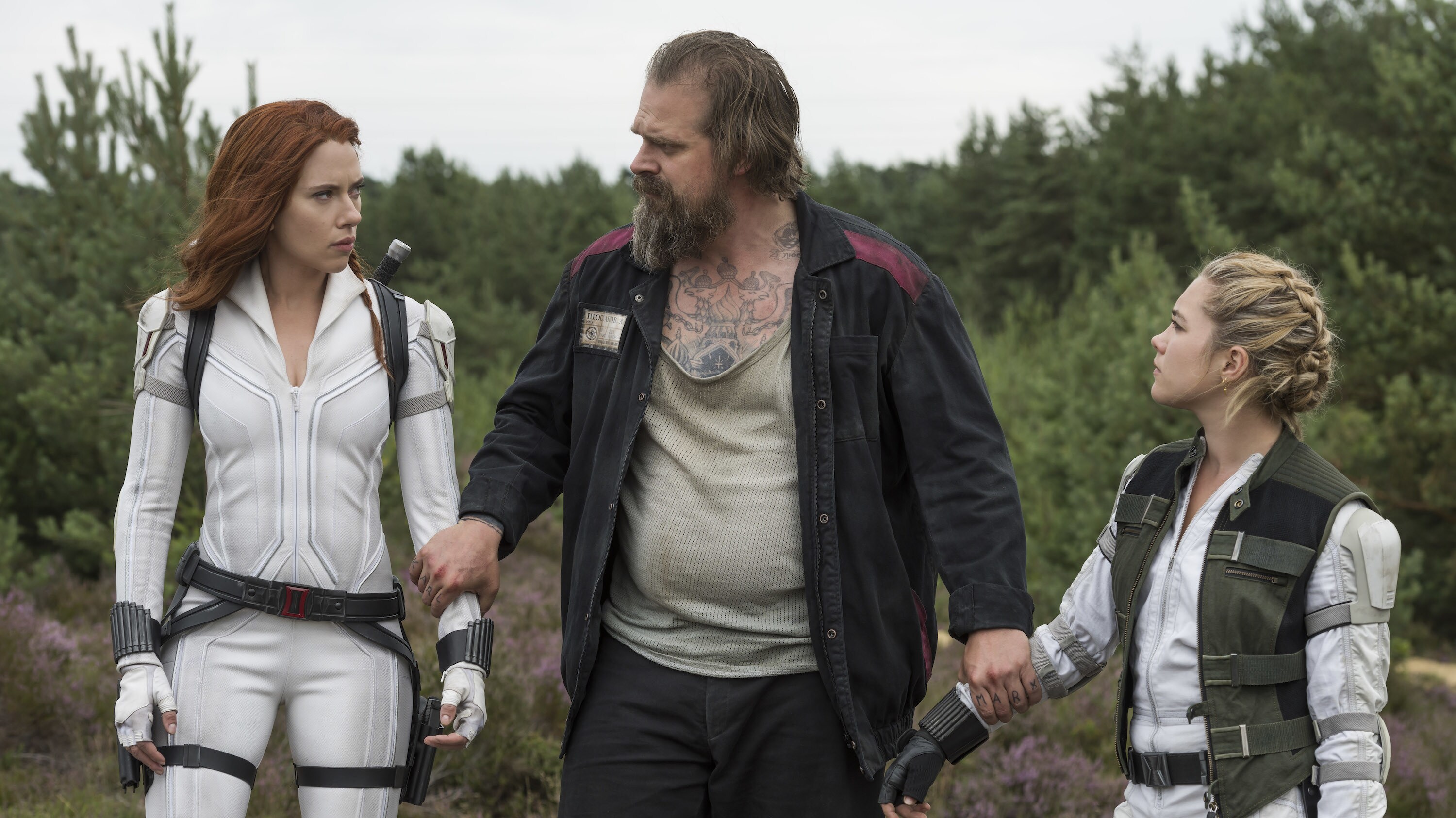 (L-R): Black Widow/Natasha Romanoff (Scarlett Johansson), Alexei (David Harbour) and Yelena (Florence Pugh) in Marvel Studios' BLACK WIDOW, in theaters and on Disney+ with Premier Access. Photo by Jay Maidment. ©Marvel Studios 2021. All Rights Reserved.