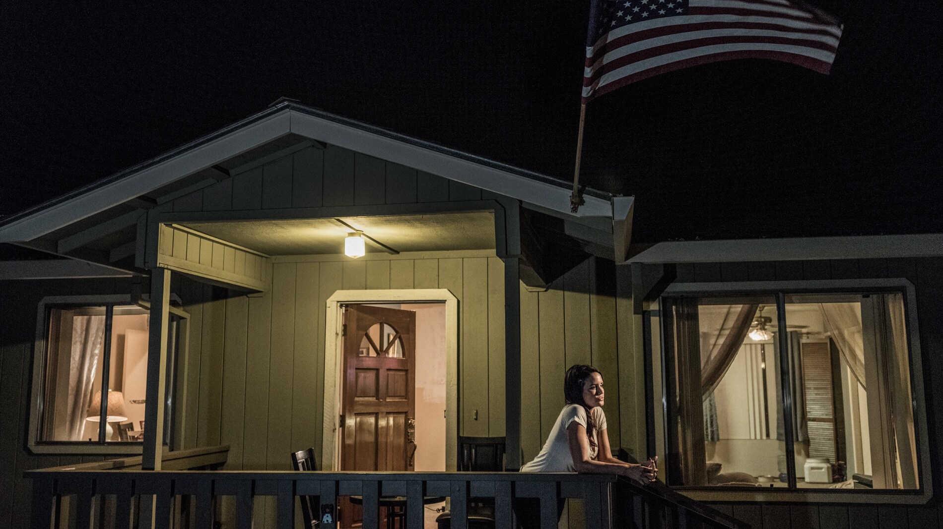 Carly Ingersoll leans on the edge of the porch of her home in Paradise, CA. (National Geographic/Pete Muller)