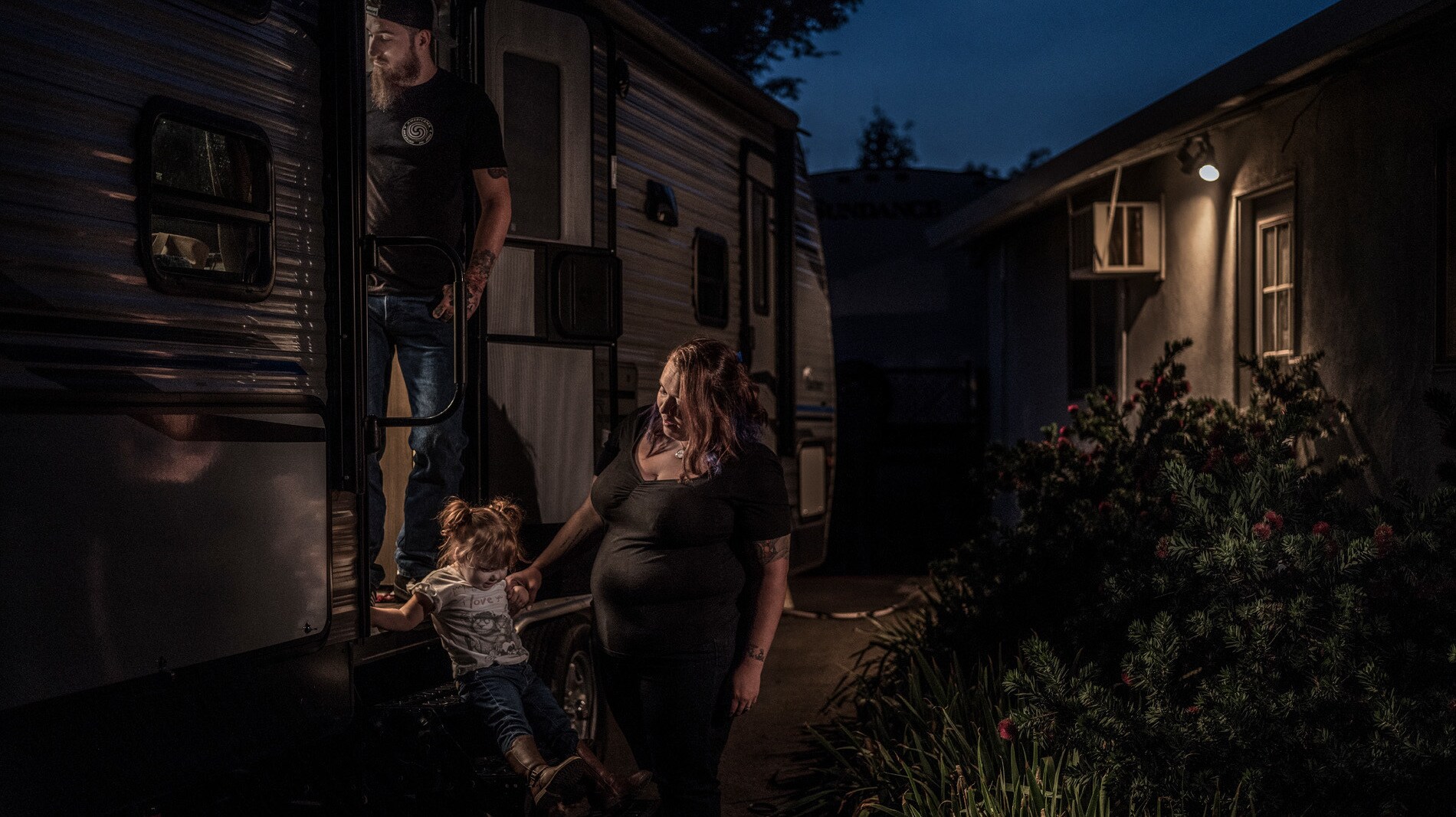 Justin, Kayla and Amberley Cox on the steps of their trailer in Paradise, CA. (National Geographic/Pete Muller)