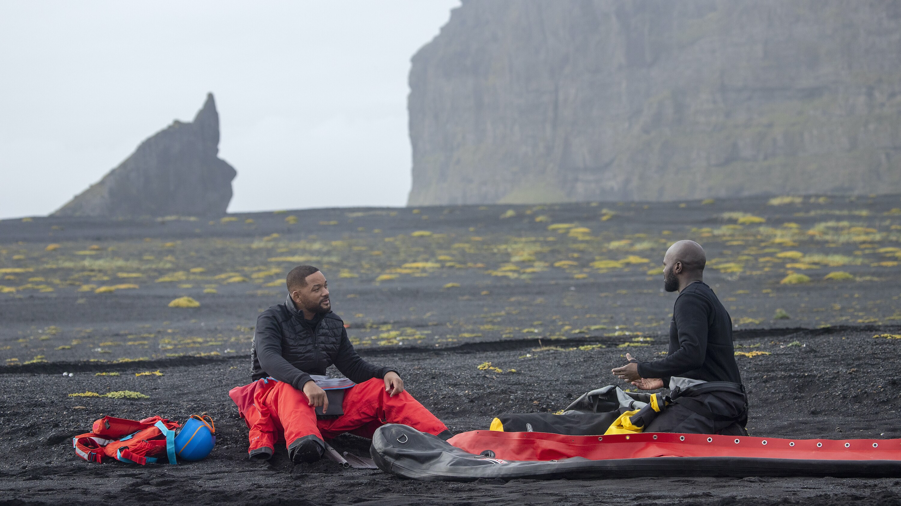 Will Smith, left, and Dwayne Fields talk on the black sand beach in Iceland.  (National Geographic for Disney+/Bragi Þór Jósefsson)