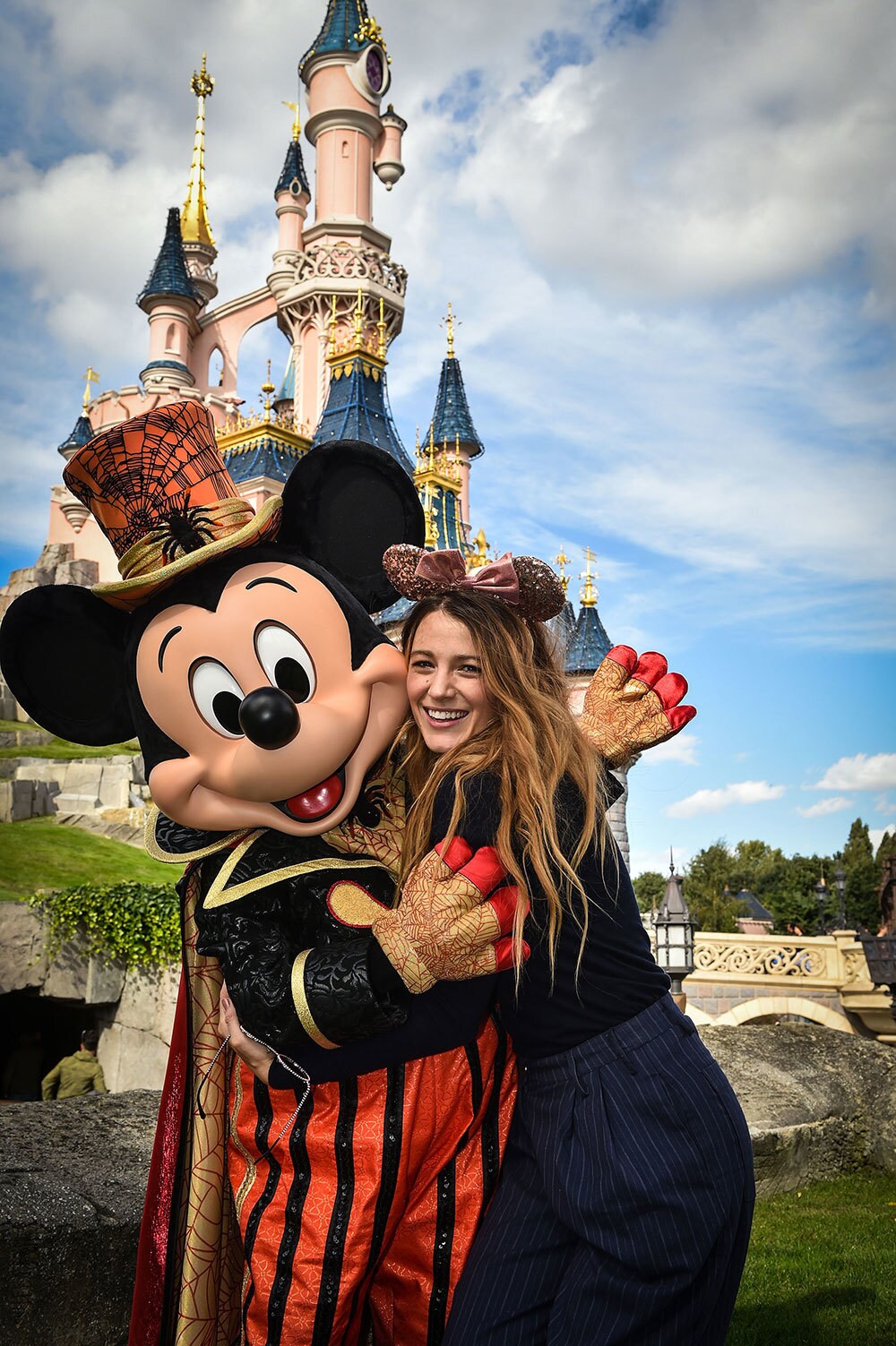 Blake Lively hugging Mickey Mouse, posing for the camera