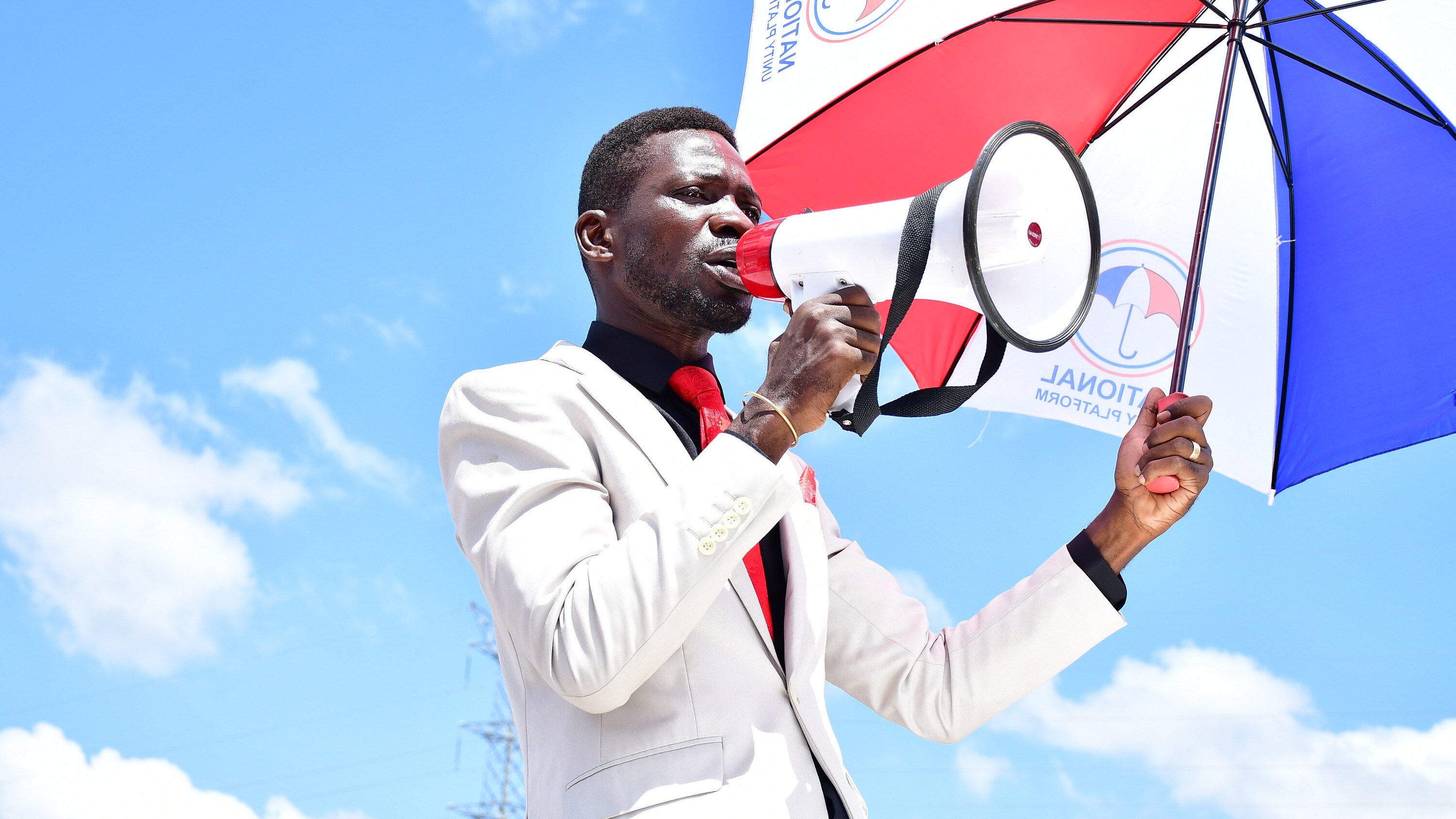 Ugandan politician Robert Kyagulanyi Ssentamu, also known as Bobi Wine, campaigns with a megaphone. Before they could re ach the campaign venue in Kumi District, he and his campaign team were tear gassed and subjected to numerous obstacles by Ugandan security forces on November 15, 2020. (photo credit: Lookman Kampala)