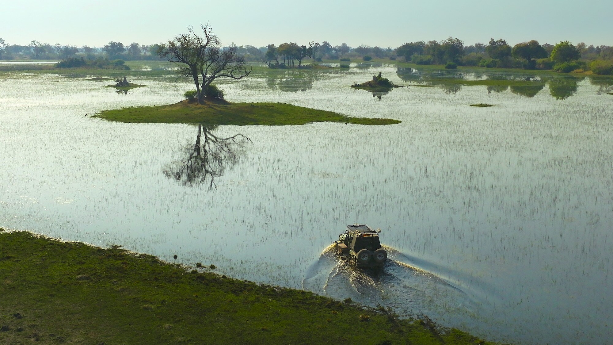4x4 driving through the flooded plain. (National Geographic for Disney+/Bertie Gregory)