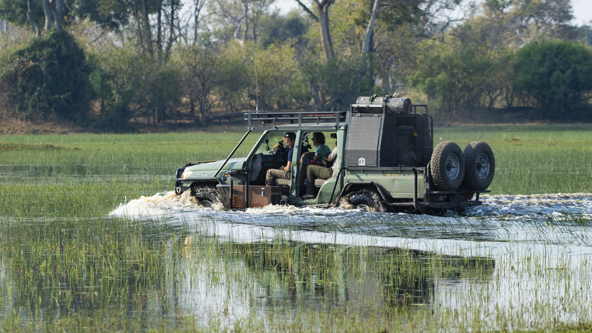 4 wheel drive carrying Bertie Gregory and crew driving through the water. (National Geographic for Disney+/Devon Jenkin)