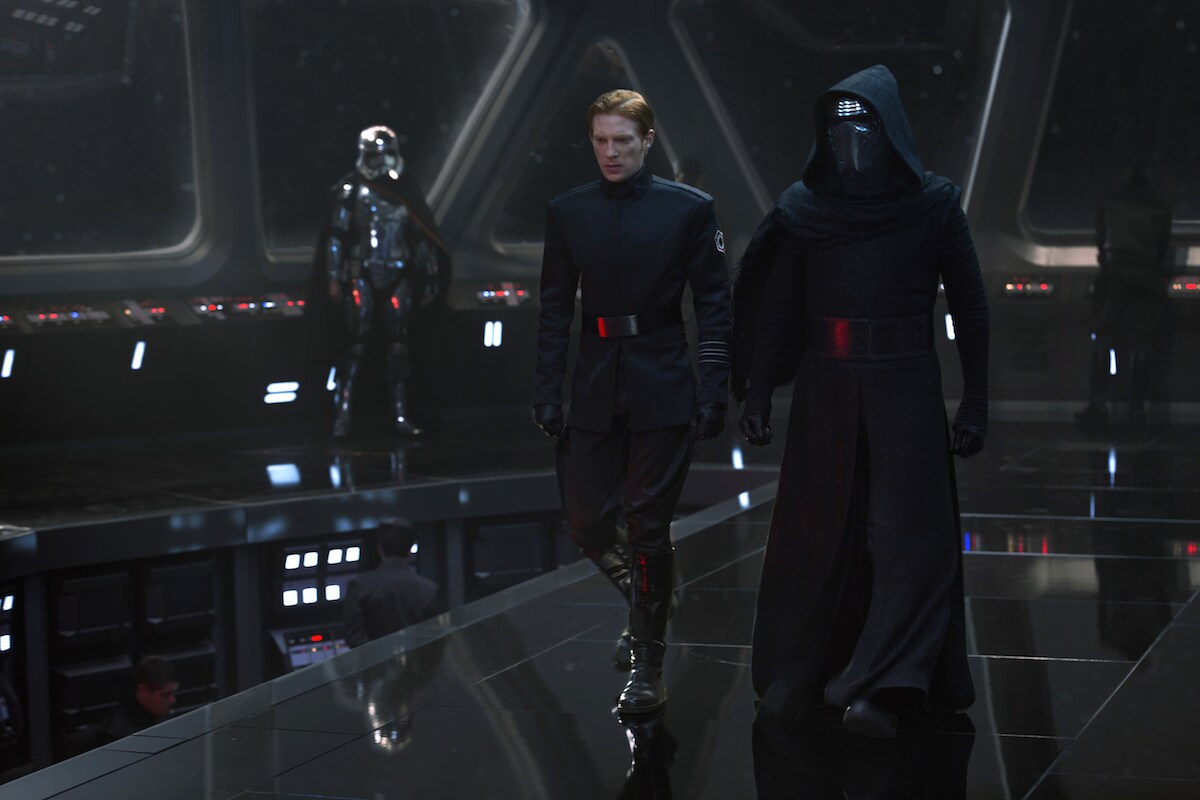 Captain Phasma standing in a command bridge as Kylo Ren and General Hux strategize