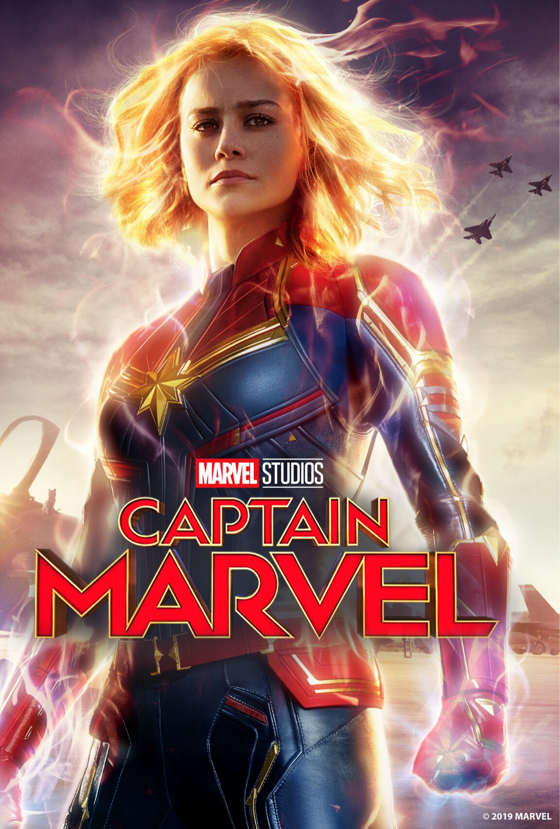 Brie Larson stands as Captain Marvel looking towards the camera, her hair flows and power appears to be flowing through her hands. The 'Marvel Studios' Captain Marvel' title is in the bottom third of the image.