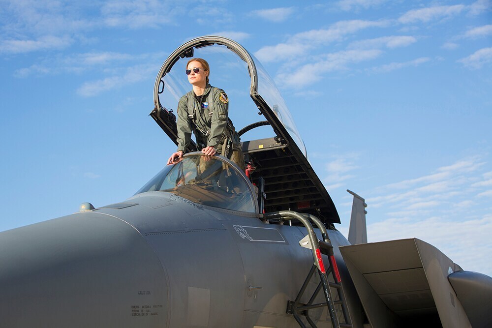 Carol Danvers (Captain Marvel) wearing flights suit and aviators in the cockpit of a fighter jet