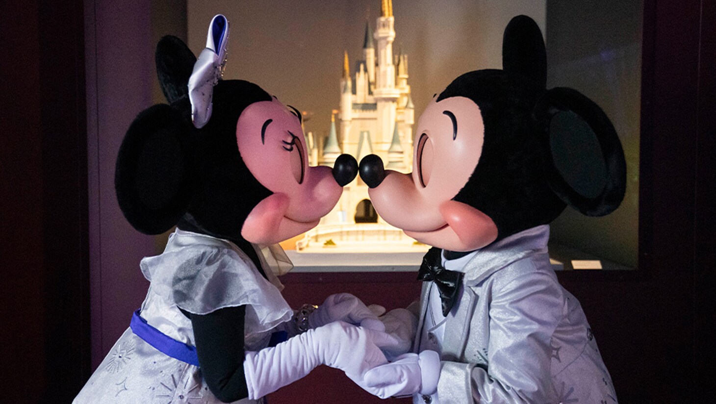Minnie Mouse and Mickey Mouse stand nose-to-nose at Disney100: The Exhibition.