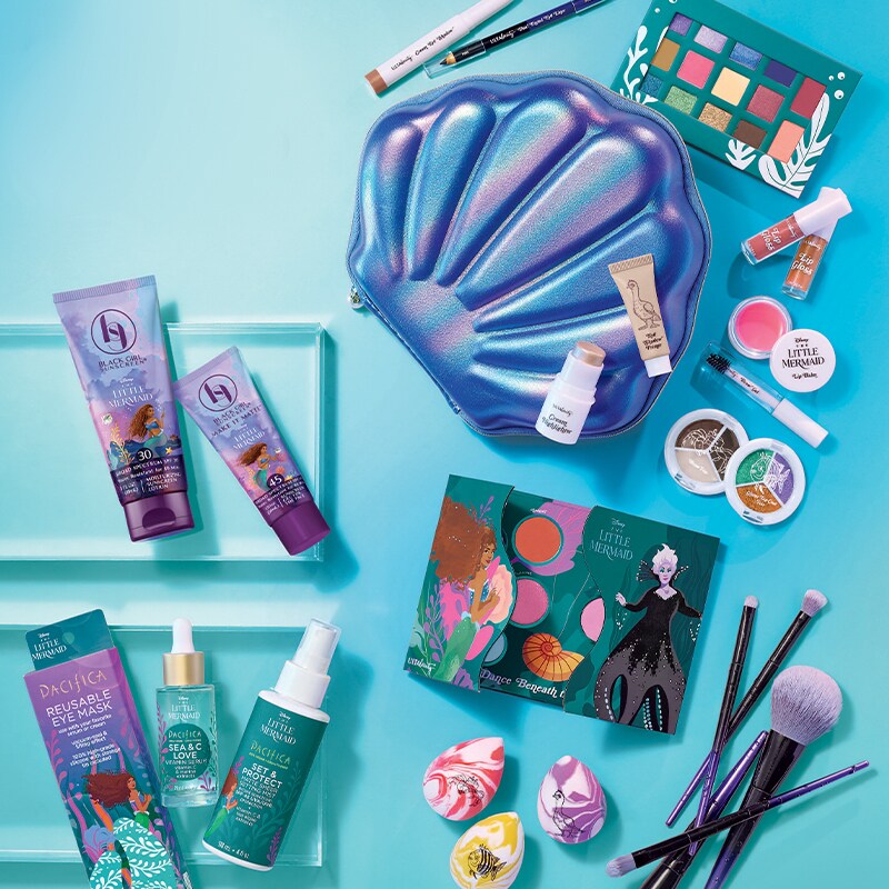Image of a selection of The Little Mermaid-themed collection of makeup products on an aqua background.