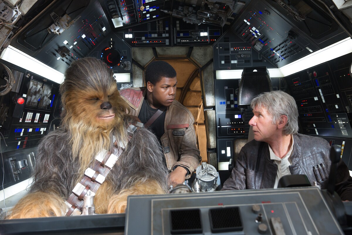 Chewbacca, Finn, and Han Solo in the cockpit of the Millennium Falcon