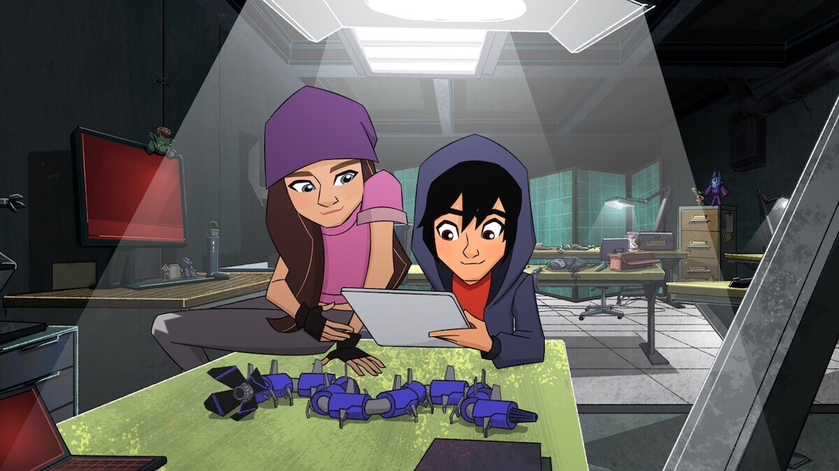 Trina and Hiro lookling at tablet with Blue Battle bot on the table