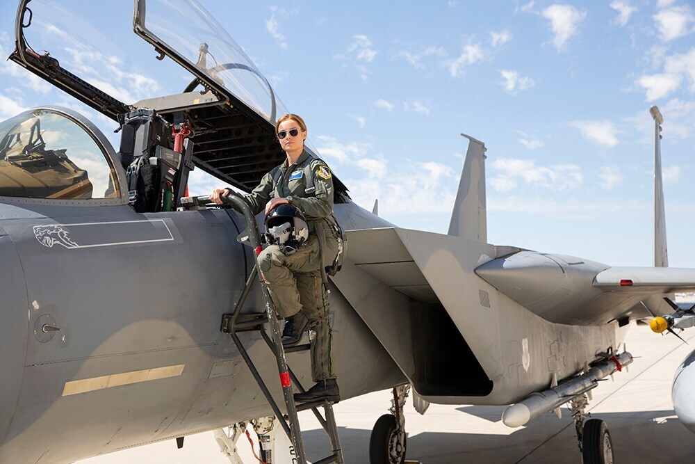 Brie Larson (Carol Danvers) on ladder next to fighter jet