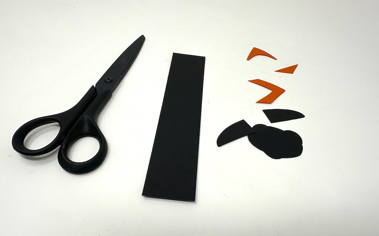 Step 4: Cut a strip of black paper, approximately 1.25 inches wide by 6 inches long.