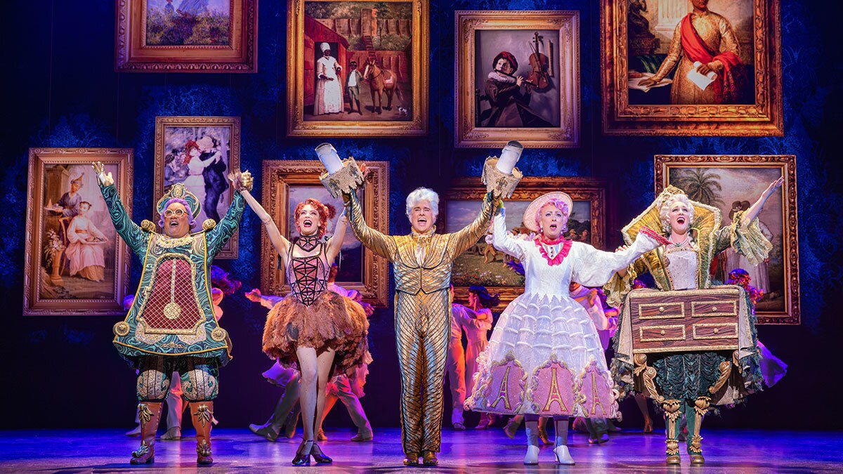Von Unruh, der Staubwedel, Lumiére, Madame Pottine und Madame Kommode halten sich freudig an den Armen, reißen sie in die Luft und singen dabei.