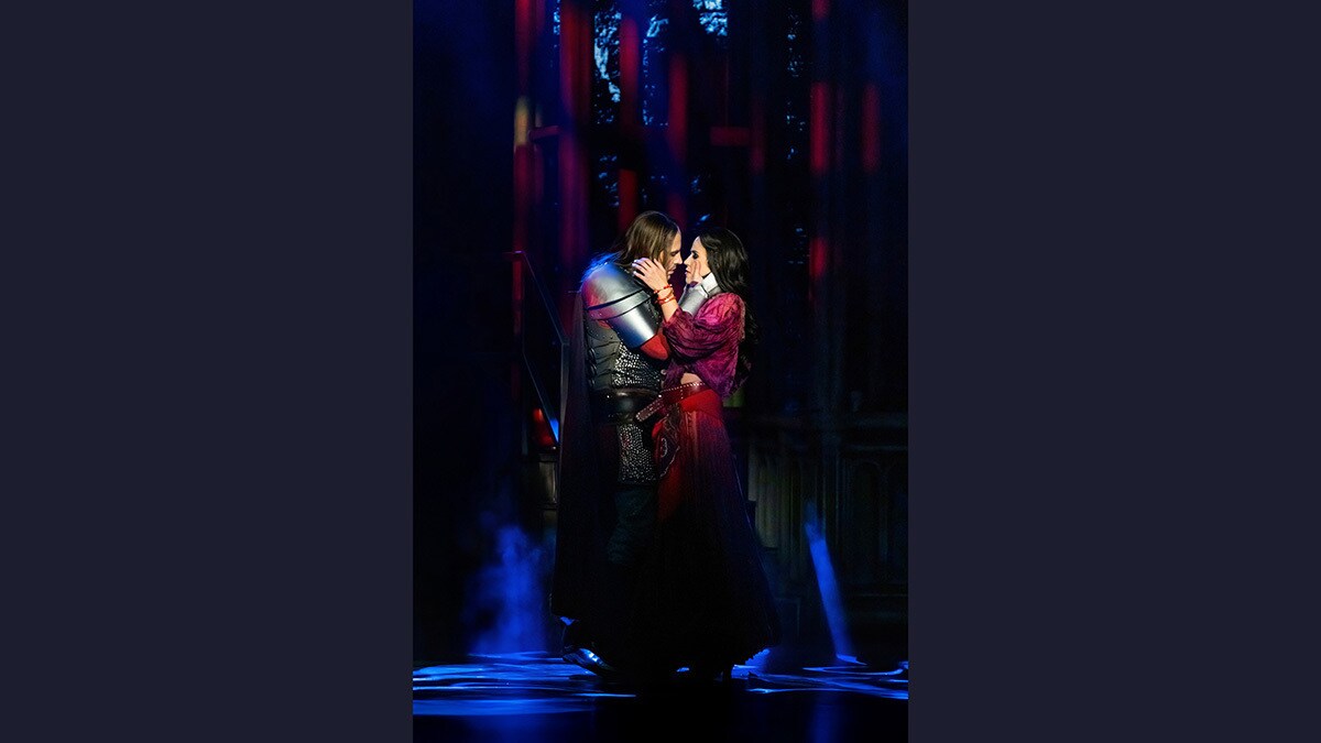 Esmeralda und Hauptmann Phoebus stehen sich eng gegenüber und halten jeweils das Gesicht des anderen. Sie küssen sich beinahe.