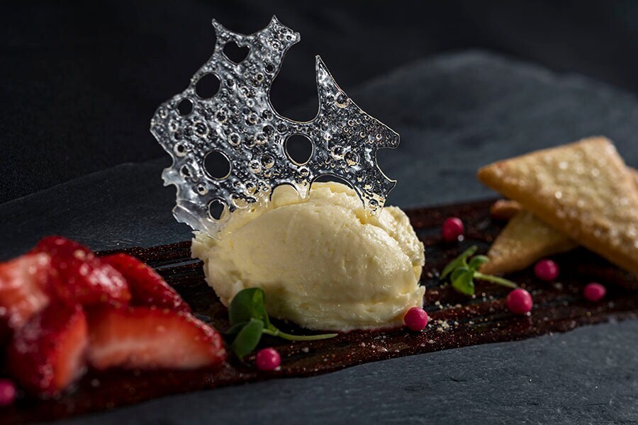 Image of deconstructed strawberry cheesecake with sugar art on top