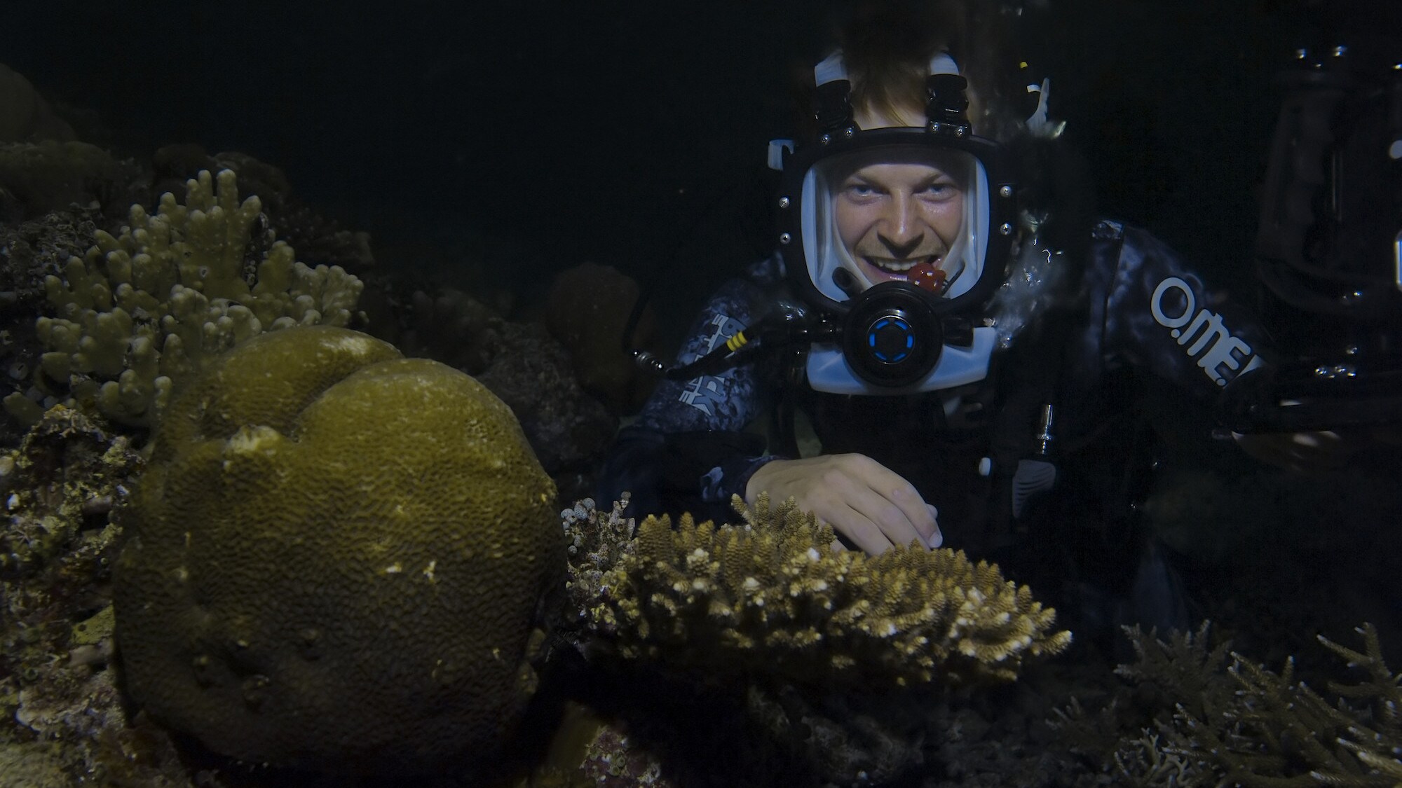 Bertie Gregory doing a piece to camera beside coral.  (National Geographic for Disney+/Dan Beecham)
