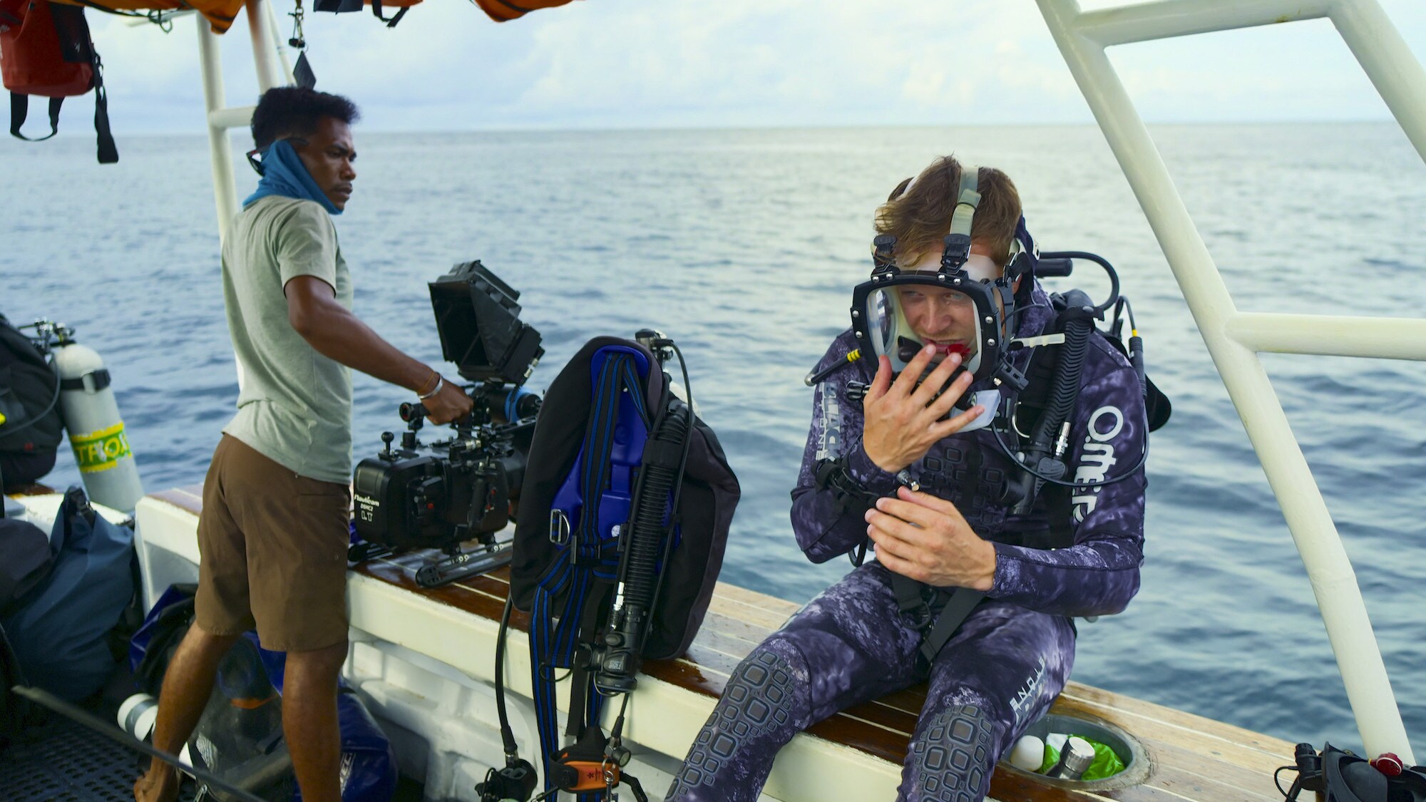 Bertie Gregory sitting on the edge of the boat getting ready to go in to the water. (National Geographic for Disney+/Spencer Millsap)