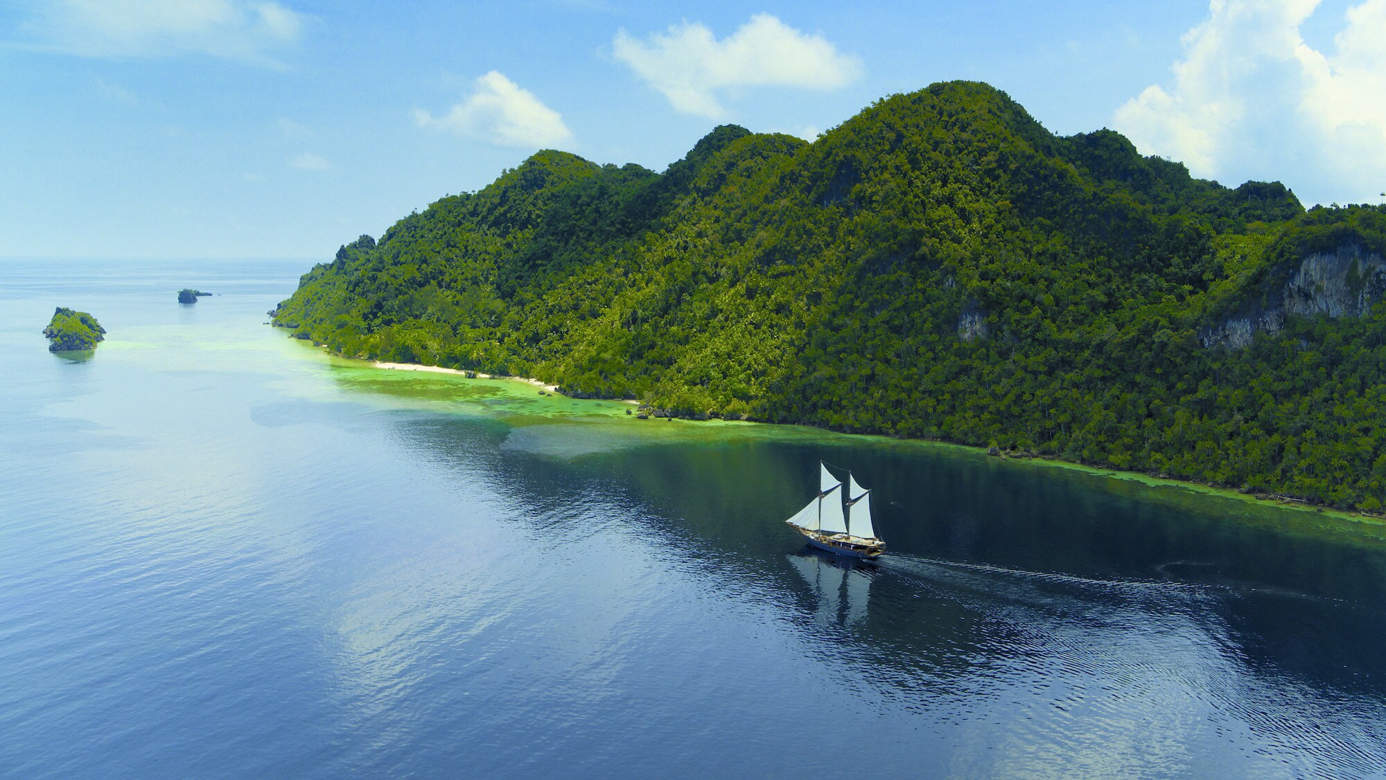 Dewata sailing with islands in the background. (National Geographic for Disney+/Bertie Gregory)