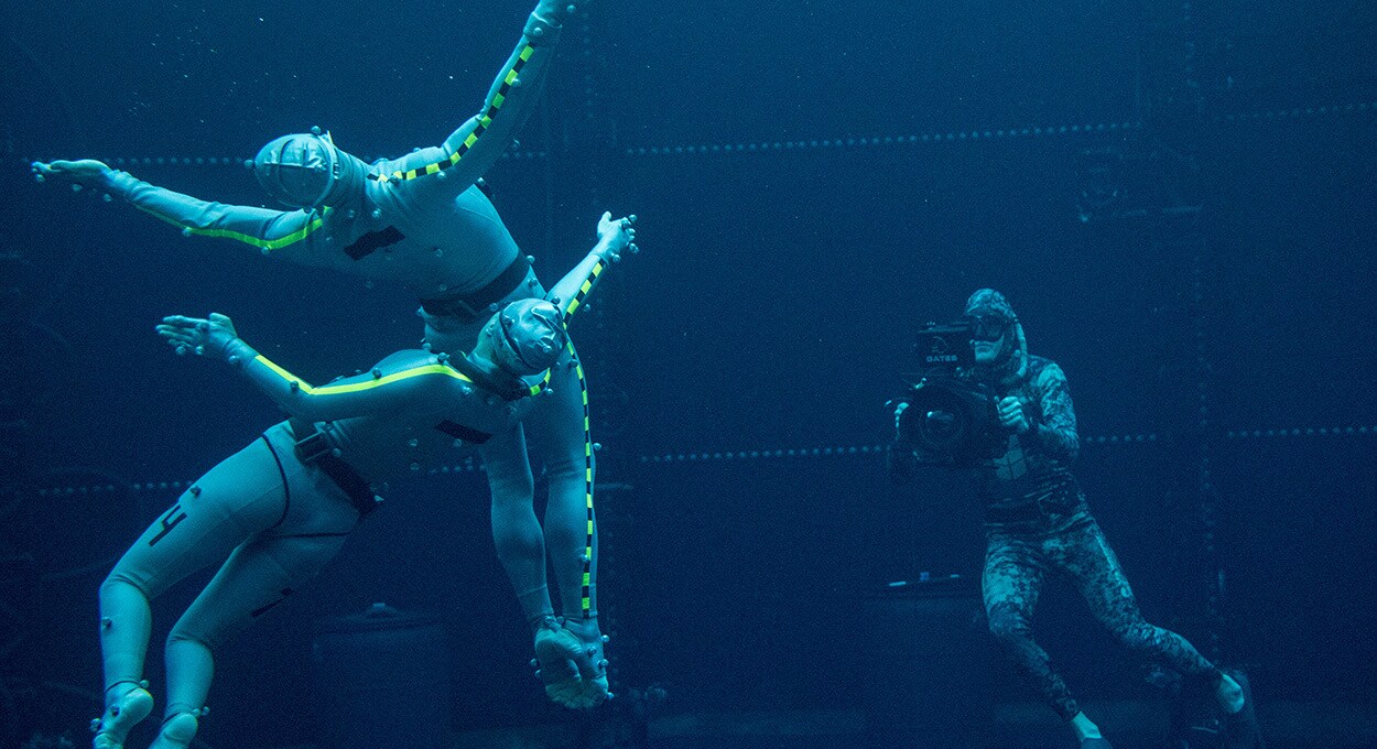 Image of two actors swimmer and one cameraman in the water while filming Avatar sequels.