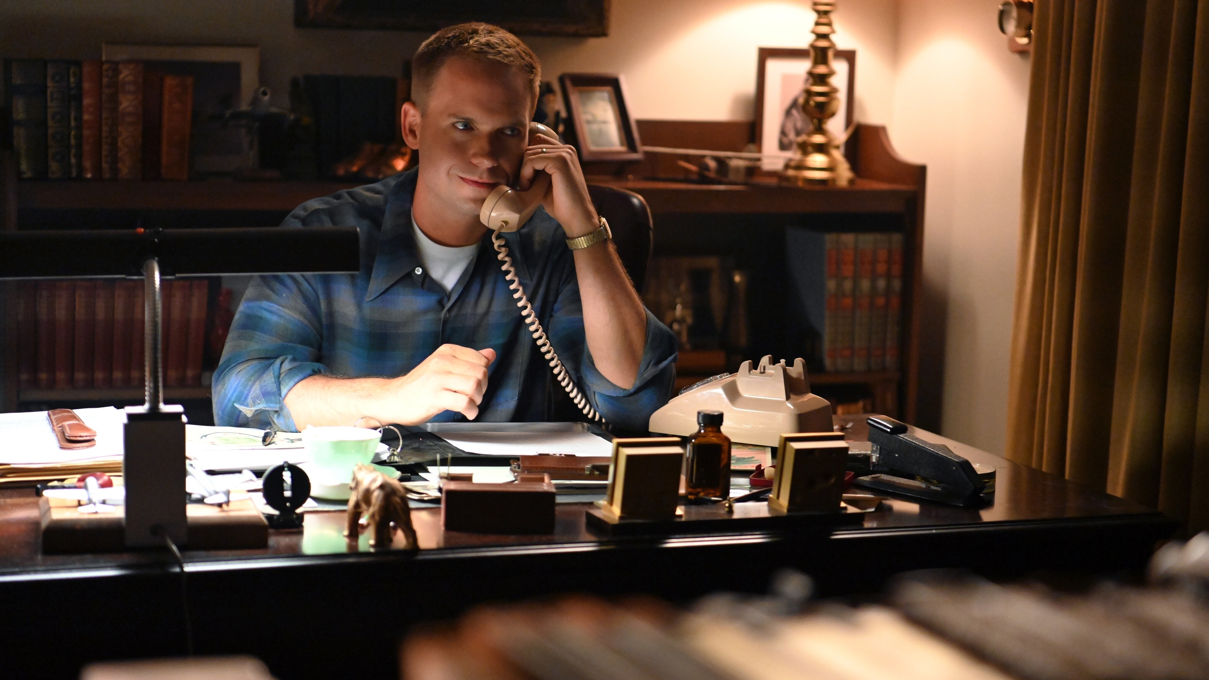 John Glenn, played by Patrick J. Adams, speaks to Bobby Kennedy on the telephone about the upcoming presidential election and the space program in National Geographic's THE RIGHT STUFF streaming on Disney+. (National Geographic/Gene Page)