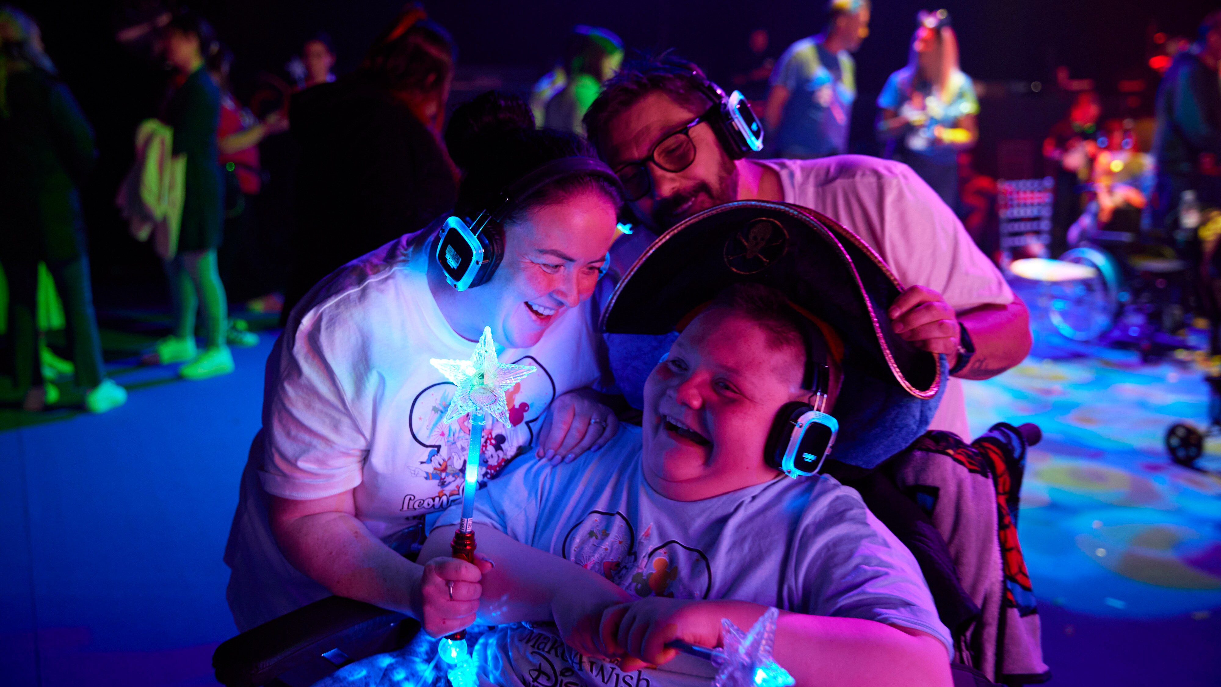 Boy with glow stick and headphones with a cast member 