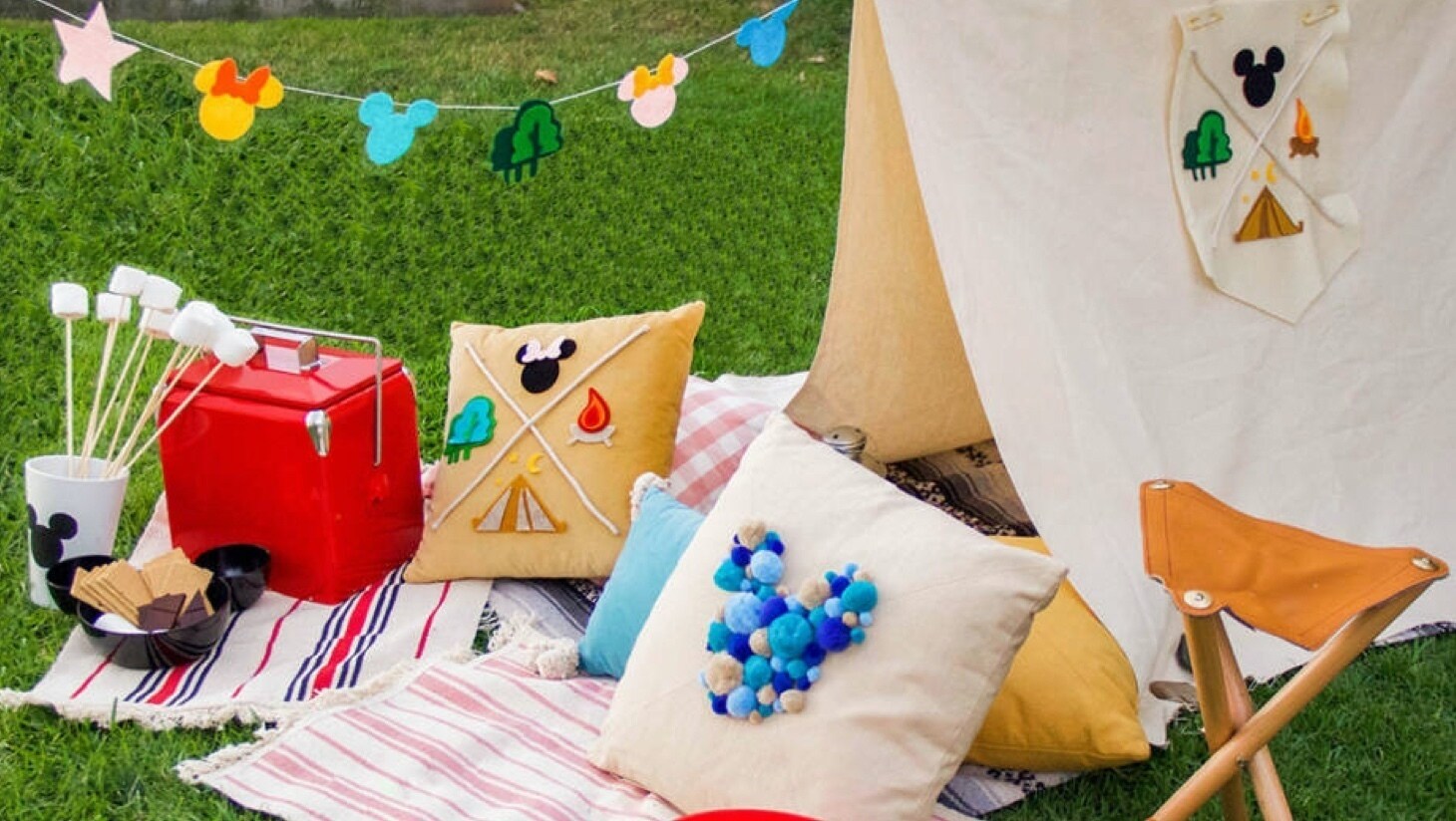 A Mickey inspired tent, cushion and snacks in a garden