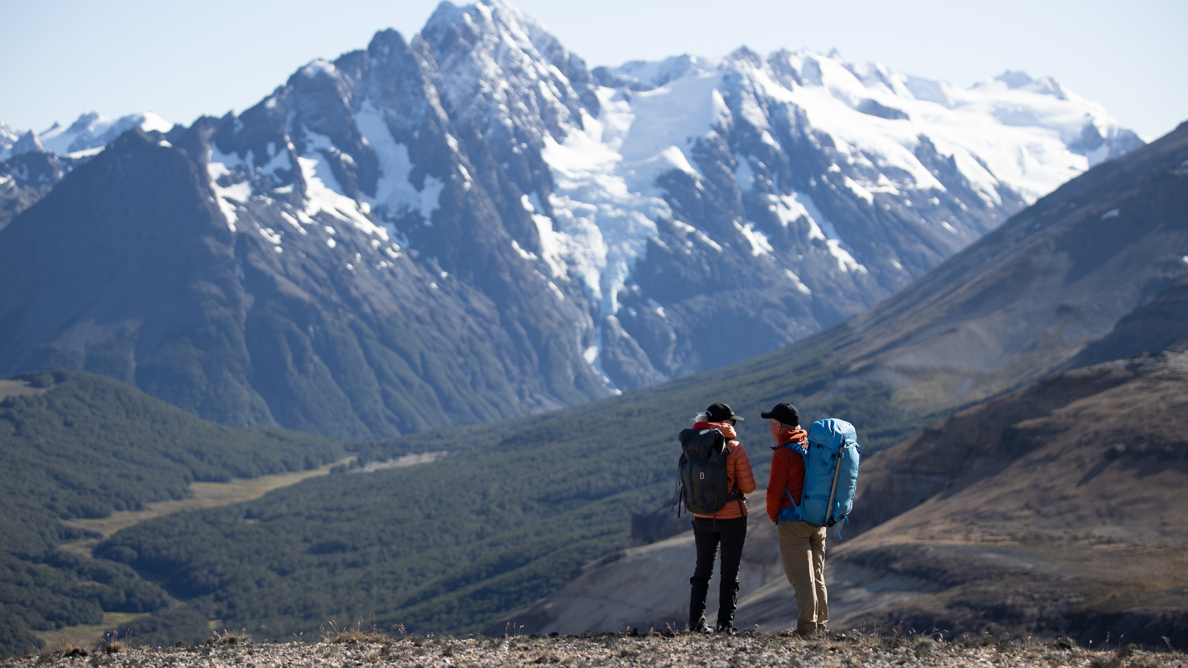 Kris Tompkins and Rick Ridgeway talking and looking out towards mountainous landscape. (Jimmy Chin)