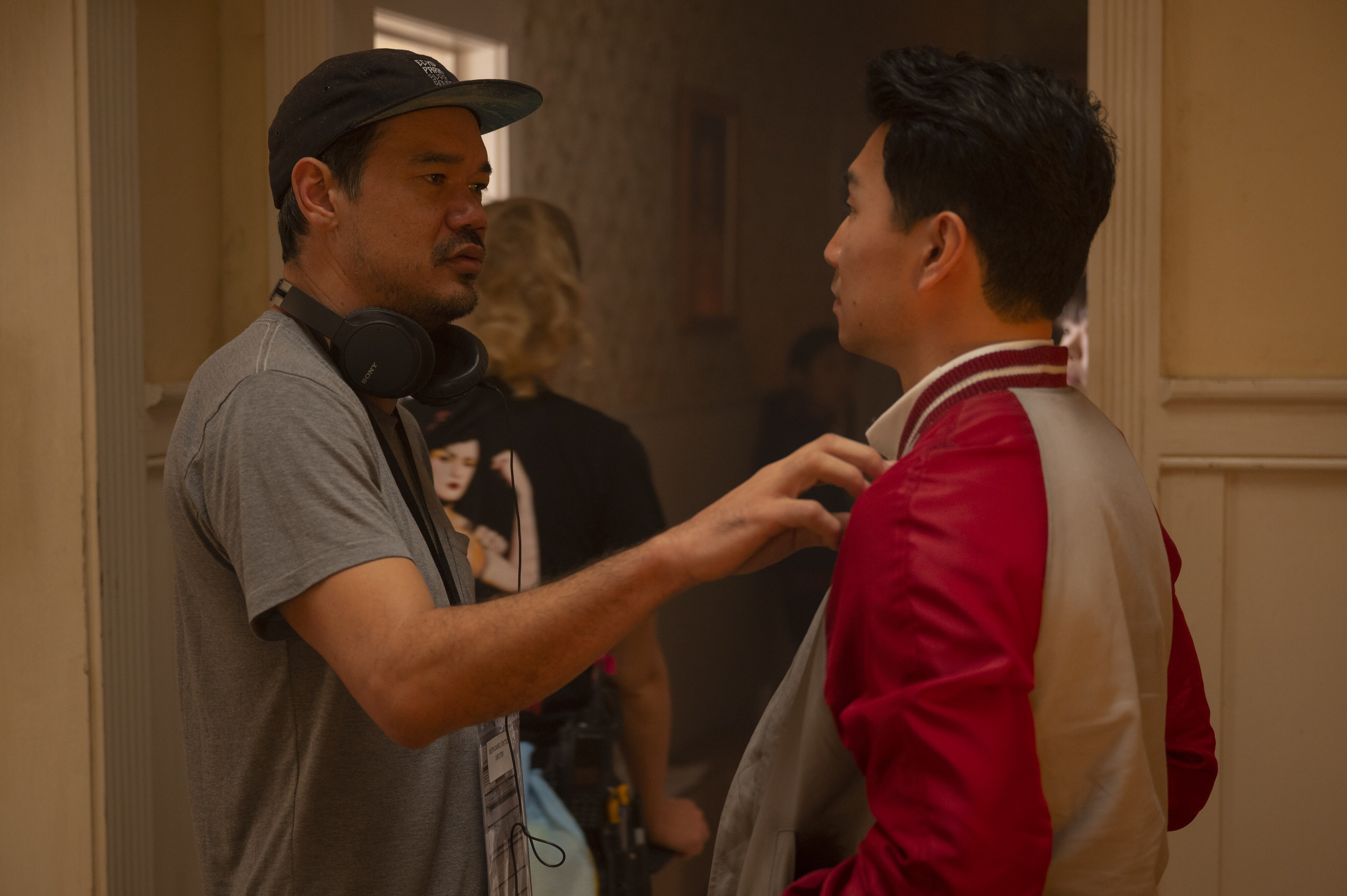 Director Destin Daniel Cretton talks with actor Simu Liu, who plays Shang-Chi, on set.