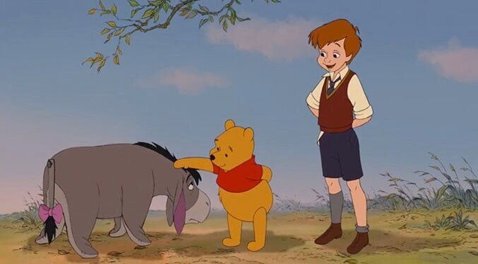 Winnie the Pooh (with Christopher Robin) patting Eeyore on the head.