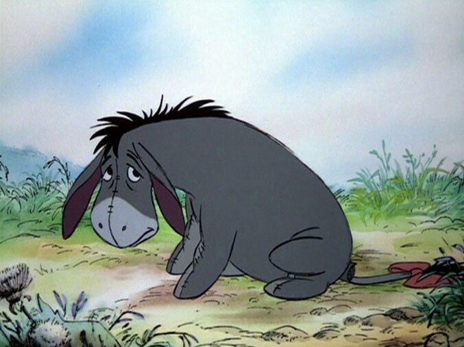 A sad Eeyore sitting on the ground.