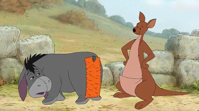 Eeyore wearing a large, orange, pinned-on tail, with Kanga.