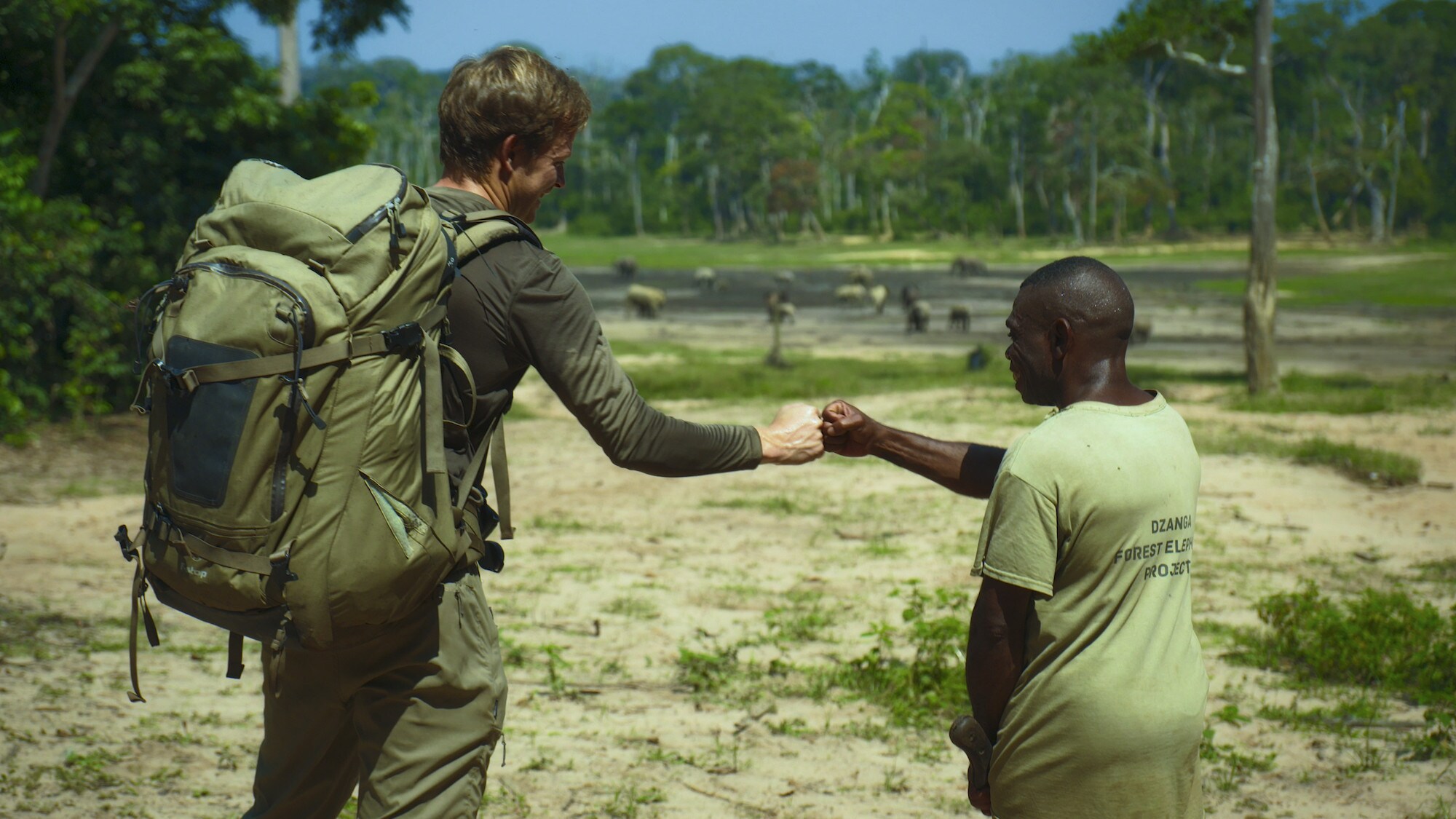 Bertie Gregory fist bumping Ngbanda Bathelomie. (National Geographic for Disney+/Mark Mclean)
