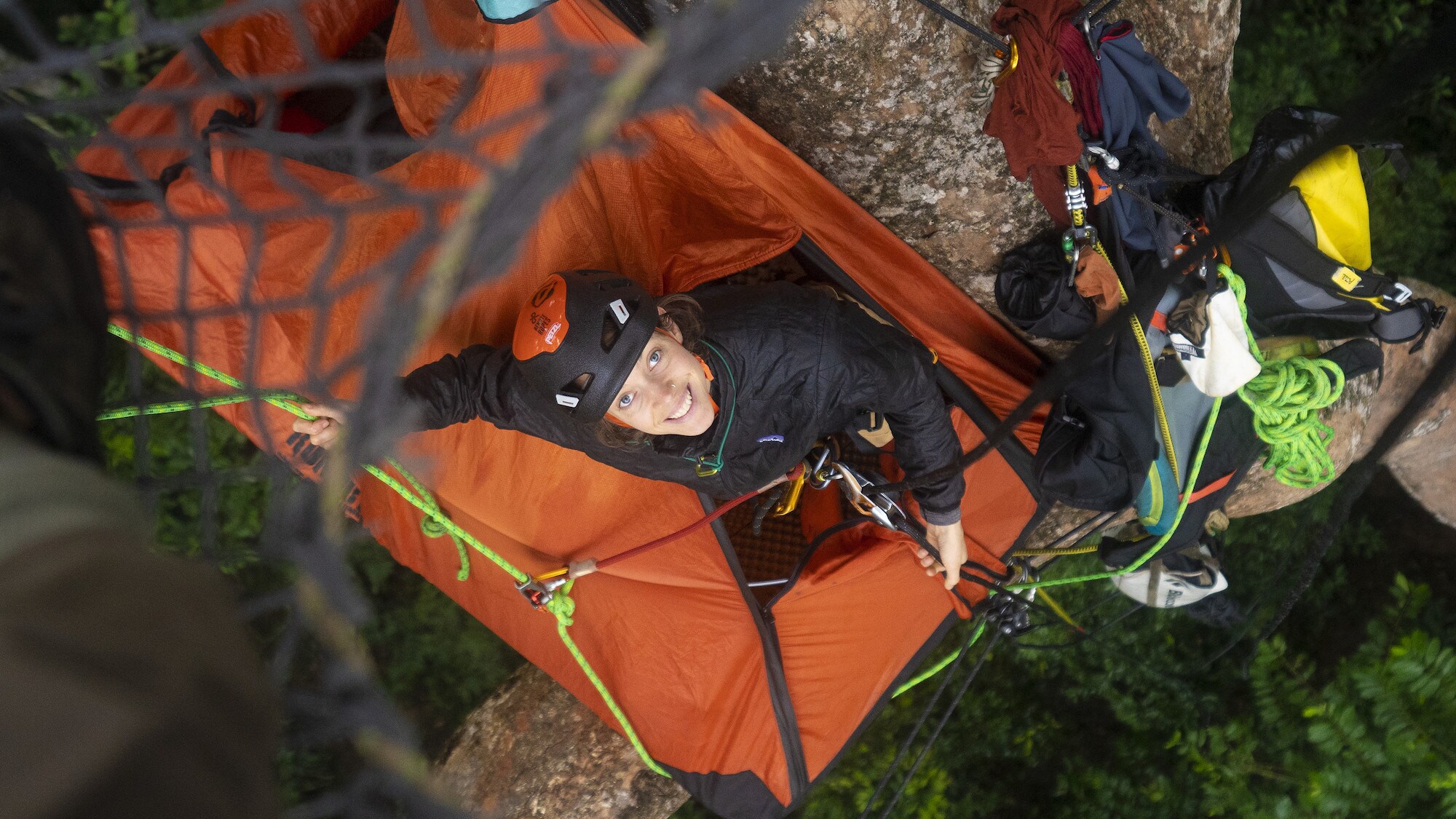 Megan Donaldson looking up at camera from her canopy tent. (National Geographic for Disney+/Waldo Etherington)