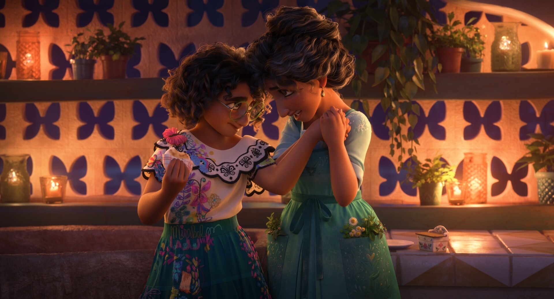 Mirabel Madrigal embraces her mom, Julieta, in Walt Disney Animation Studios' Encanto.