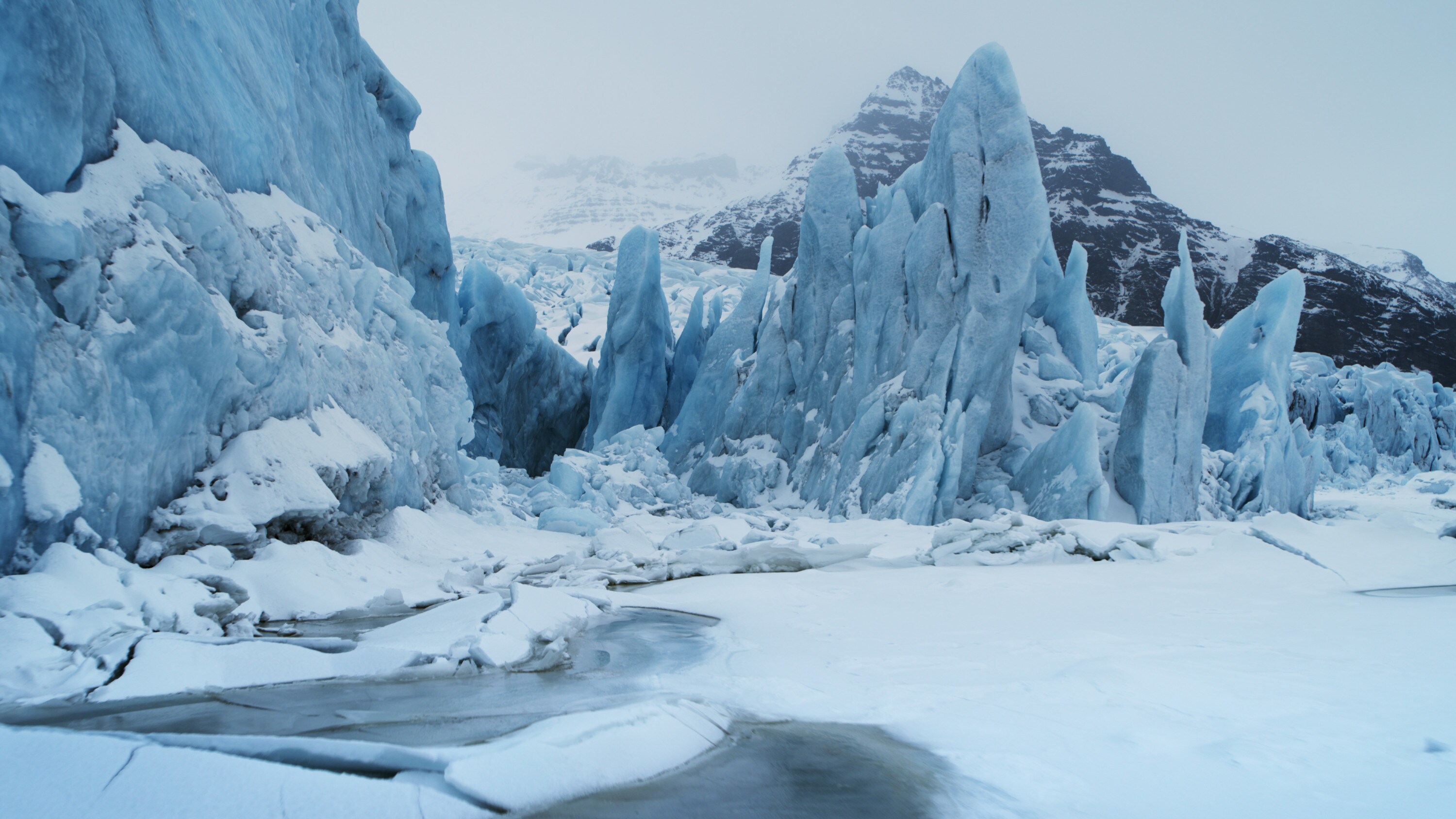 A glacier in Jökulsárlón National Park with mountains in the distance. (National Geographic for Disney+)